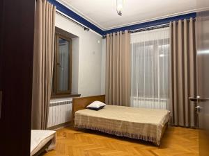 a small bedroom with a bed and a window at Просторный дом с садом in Qŭyliq +5 photos