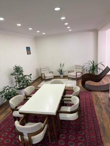 a conference room with a white table and chairs at Просторный дом с садом in Qŭyliq