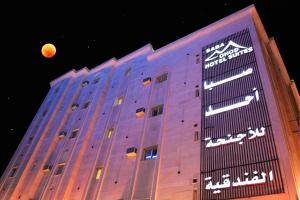 a building with the moon in the background at Saba Ohod For Hotel Suites in Medina