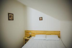 um quarto com uma cama branca e uma cabeceira em madeira em Ungweiser em Uzhhorod