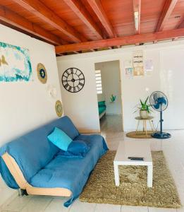 a living room with a blue couch and a table at Villa élégante à Anse-Bertrand avec piscine in Anse-Bertrand +8 photos
