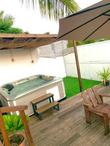 a hot tub sitting on a deck with an umbrella at Villa élégante à Anse-Bertrand avec piscine in Anse-Bertrand