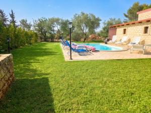 a yard with lounge chairs and a swimming pool at Charming Villa in Noto with Private Pool in Noto