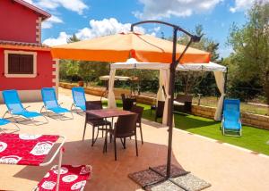 a patio with a table and an umbrella at Charming Villa in Noto with Private Pool in Noto