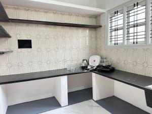 a kitchen with black counter tops in a room at DM Bliss in Chikmagalūr