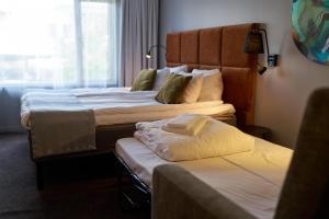 a hotel room with two beds and a window at Scandic Laholmen in Strömstad
