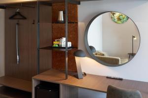 a room with a mirror and a desk with a chair at Scandic Laholmen in Strömstad