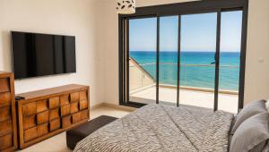 a bedroom with a bed and a large window with the ocean at Sea-View Villa with Infinity Pool Algiers in Tipaza