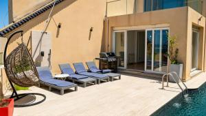 a patio with lounge chairs and a swimming pool at Sea-View Villa with Infinity Pool Algiers in Tipaza