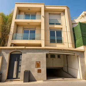 an apartment building with a garage in front of it at Sea-View Villa with Infinity Pool Algiers in Tipaza