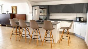 a kitchen with a counter and a group of stools at Sea-View Villa with Infinity Pool Algiers in Tipaza +43 photos