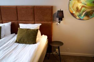 a bedroom with a bed with a green pillow on it at Scandic Laholmen in Strömstad