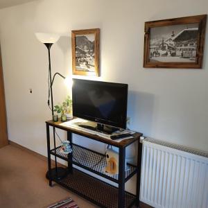a desk with a computer monitor and a lamp on it at Pretzners Ferienwohnungen in Reit im Winkl