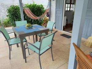 a wooden table and chairs on a patio at Villa élégante à Bouillante avec piscine privée in Bouillante