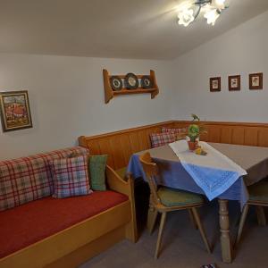 a dining room with a table and a table and chairs at Pretzners Ferienwohnungen in Reit im Winkl