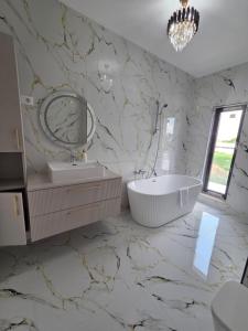 a bathroom with a tub and a sink and a mirror at Vila Lux Braila in Brăila +15 photos