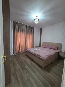 a bedroom with a large bed and a window at Vila Lux Braila in Brăila