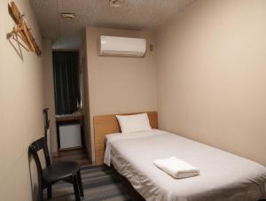 a small room with a bed and a chair at Tsukuba Daily Inn in Tsukuba +19 photos