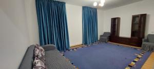 a living room with blue curtains and a couch at Арай 2 - 116 in Qyzylorda +2 photos