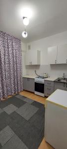 a kitchen with white cabinets and a curtain in a room at Арай 2 - 116 in Qyzylorda