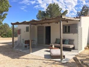 a small house with a pergola and a table at Comfortable House in Formentera with Garden and Terrace in Sant Francesc Xavier