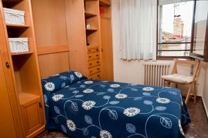 1 dormitorio con 1 cama con edredón azul y ventana en Palacio Gómara-Bardenas, en Valtierra
