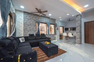 ein Wohnzimmer mit schwarzem Sofa und einer Backsteinwand in der Unterkunft II EMPYREAN STAYS II SU CASA VILLA II 4BHK II AC II PRIVATE POOL Il in Lonavla
