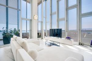 a living room with white furniture and large windows at Penthouse With The Best Views! in Barcelona