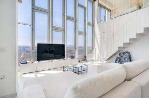 a living room with a large white couch and a tv at Penthouse With The Best Views! in Barcelona