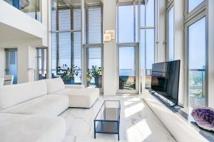 a living room with a white couch and a tv at Penthouse With The Best Views! in Barcelona