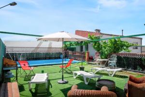 a patio with chairs and tables and an umbrella at Charming Villa in Vitigudino with Private Pool in Vitigudino