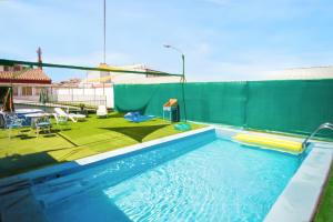 a swimming pool with a green privacy fence and a swimming pool at Charming Villa in Vitigudino with Private Pool in Vitigudino