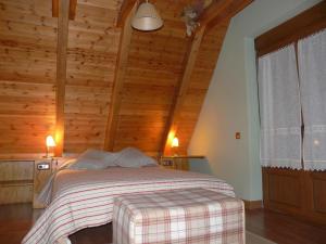 a bedroom with a bed with a wooden wall at Charming Chalet in Viella, Mountain View in Vielha