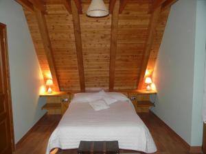 a bed in a room with wooden walls and a ceiling at Charming Chalet in Viella, Mountain View in Vielha