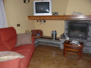 a living room with a red couch and a fireplace at Charming Chalet in Viella, Mountain View in Vielha