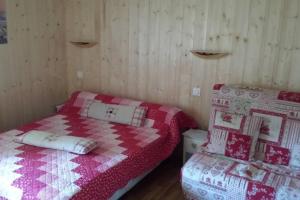 a bedroom with two beds with red and white quilts at Appartement confortable à Gérardmer 40 m² proximité pistes in Gérardmer