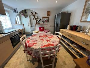 a kitchen with a table and a kitchen with a refrigerator at Appartement confortable à Gérardmer 40 m² proximité pistes in Gérardmer