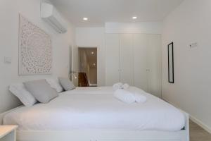 a white bedroom with two white towels on a bed at GuestReady - Sea Apartments in São Roque