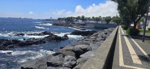 a walkway next to a body of water with rocks at GuestReady - Sea Apartments in São Roque
