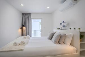 a white bedroom with a large bed with white pillows at GuestReady - Sea Apartments in São Roque +89 photos