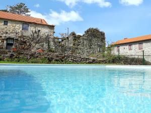 ein altes Steingebäude und ein Schwimmbad in der Unterkunft Cozy studio with mountain view - 20 m² - Águeda in Urgueira