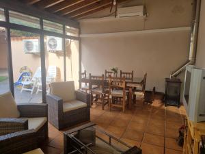 a living room with a table and chairs and a television at Charming villa in Pajares de la Lampreana with private pool in Pajares de la Lampreana