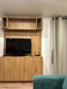 a flat screen tv sitting on top of a wooden entertainment center at EkoOazy nad Jeziorem in Firlej
