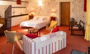 a bedroom with a bed and a couch in a room at Studio confortable à Thilouze de 55 m² avec jardin privatif in Thilouze