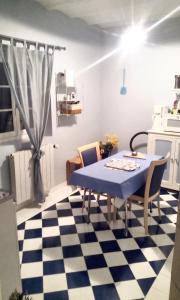 a kitchen with a blue table and chairs on a checkered floor at Studio confortable à Thilouze de 55 m² avec jardin privatif in Thilouze
