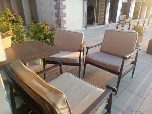two chairs and a table and a wooden table and chairs at Okan Ali Gürsoy Otel in Ayvalık