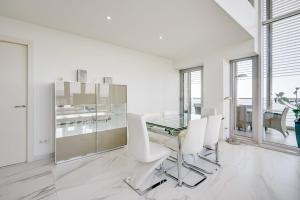 a dining room with a glass table and white chairs at Penthouse With The Best Views! in Barcelona +43 photos