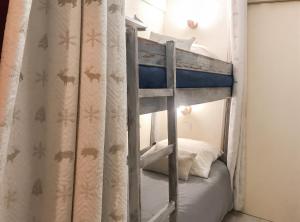 a bunk bed in a room with a curtain at Studio chaleureux à Uvernet-Fours, 25m² avec vue montagne in Uvernet +52 photos