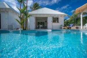 a swimming pool in front of a villa at Villa spacieuse à Hyacinthe, Le Robert avec piscine privée in Le Robert +22 photos