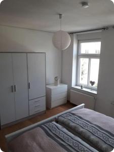 a white bedroom with a bed and a window at Specht-Ferienwohnung-1-Tangermuende in Tangermünde